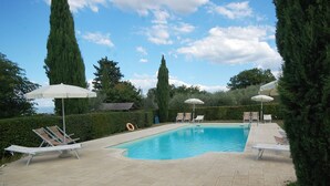 A rectangular swimming pool with a tiled deck, surrounded by lounge chairs and umbrellas. - Agriturismo for 4 with a shared pool, by a village (Casole d'Elsa)
