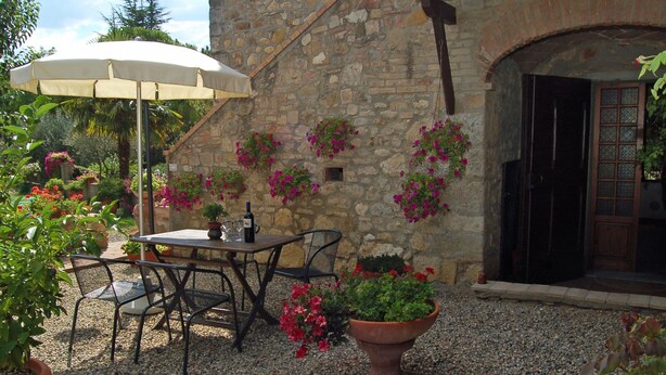 An outdoor patio with a table and chairs, surrounded by potted plants and flowers. - Agriturismo for 4 with a shared pool, by a village (Casole d'Elsa)