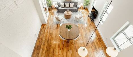 A modern living room with a wooden floor, a round coffee table, and a sofa set.
