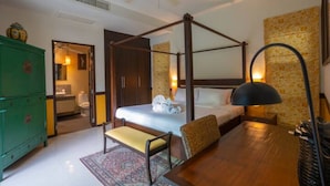 A four-poster bed with a wooden frame, a bedside table with a lamp, a green cabinet, and a bathroom visible through an open door. - Summer Dream (Rawai)