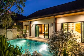 Ein modernes Haus mit Swimmingpool, großen Glasfenstern und einem hellen Innenraum.