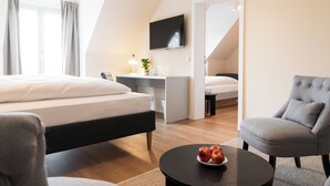 Una habitación de hotel moderna con una cama, un escritorio, una silla y un televisor.