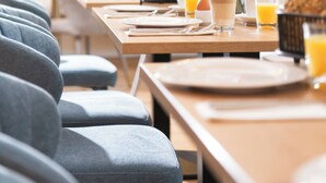 Un ambiente de desayuno con una mesa de buffet, asientos y vistas al exterior.
