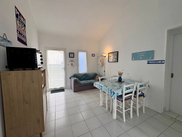 A compact living space with a kitchenette, a dining area, and a seating area.