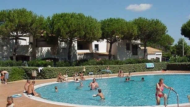 Una piscina rodeada de árboles y edificios.