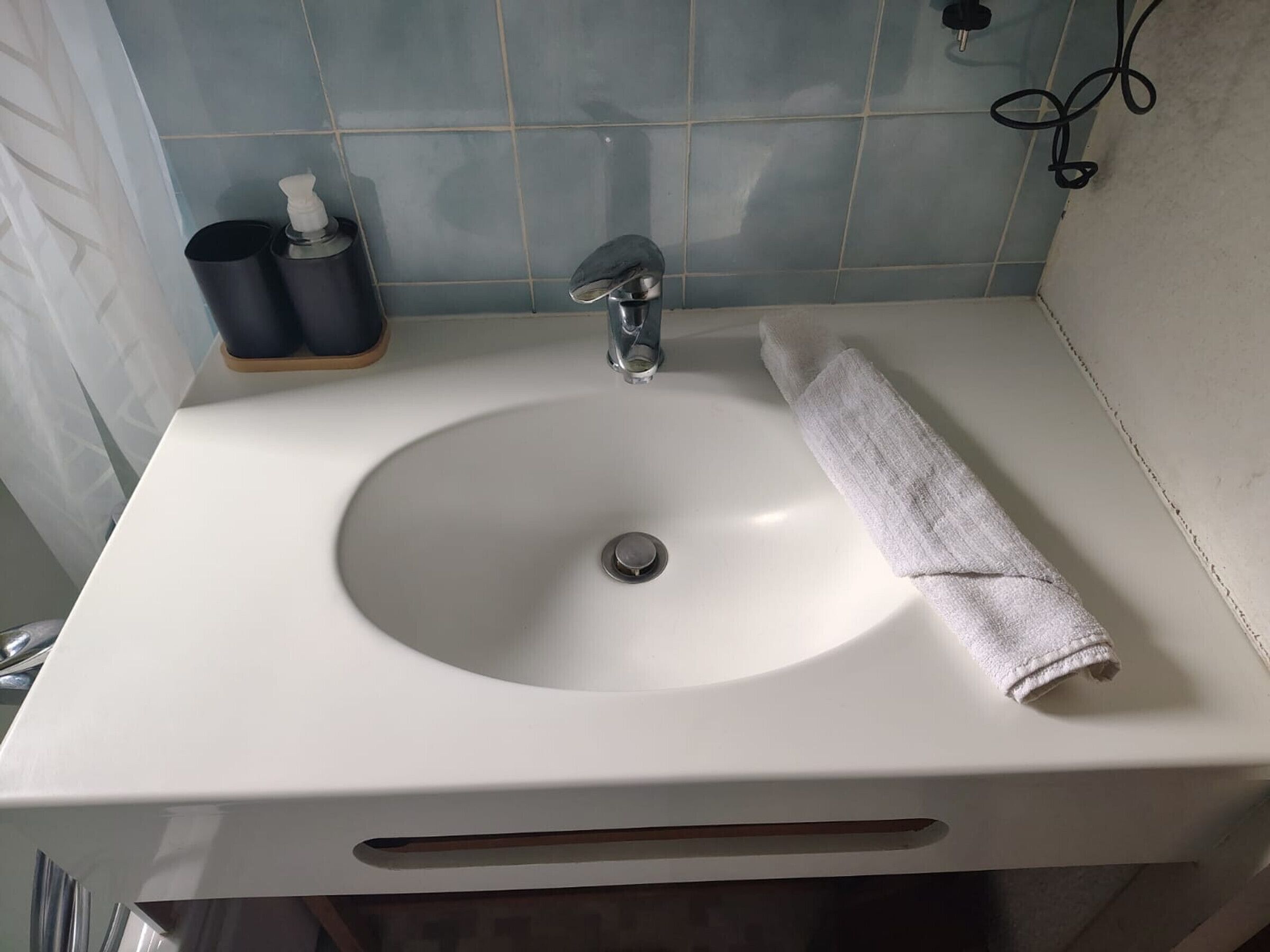 Pesualta, jossa on pyyhe, saippua-annostelija ja hammasharjateline.