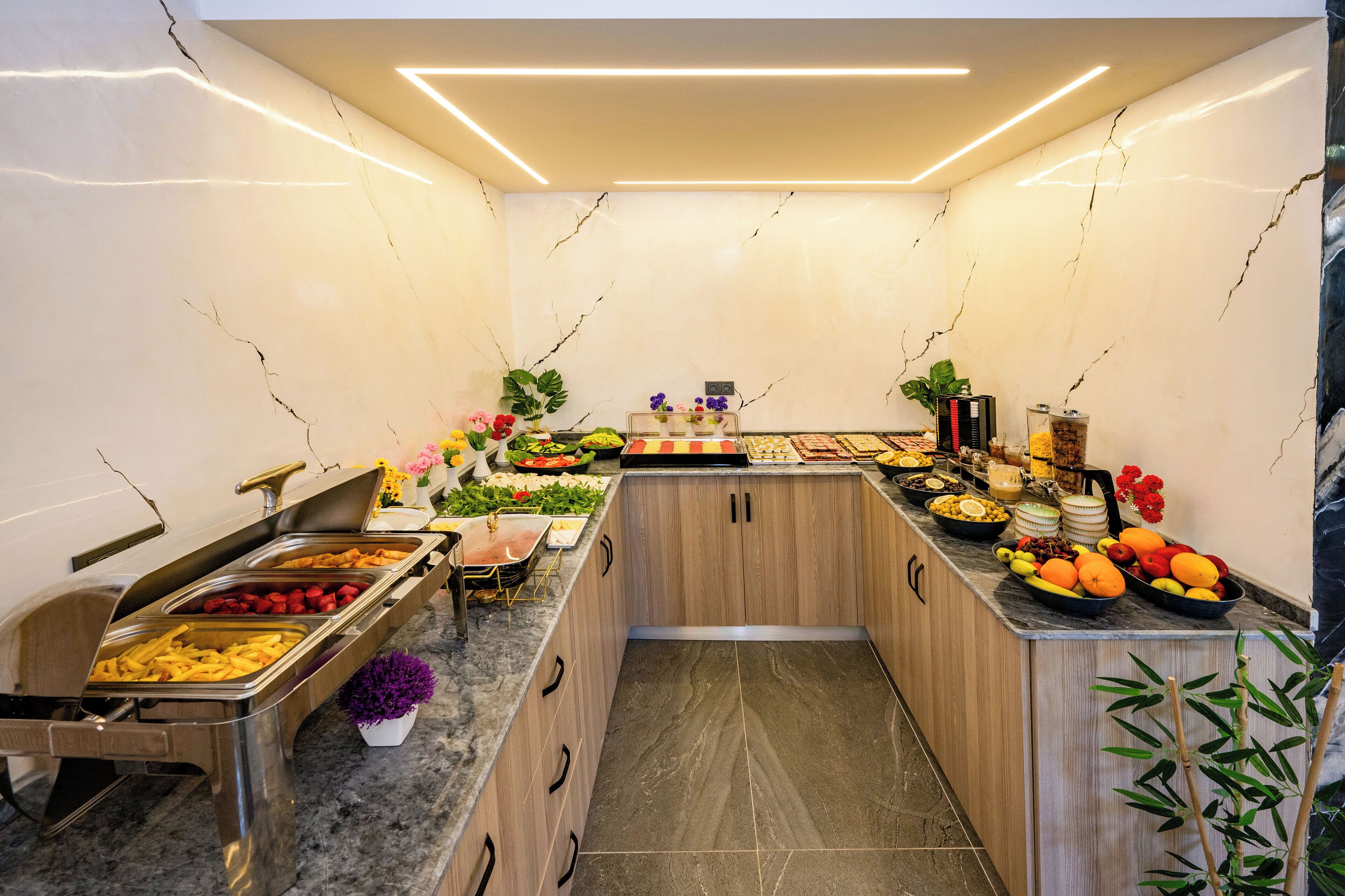 A buffet setup with various food items and a decorative plant.