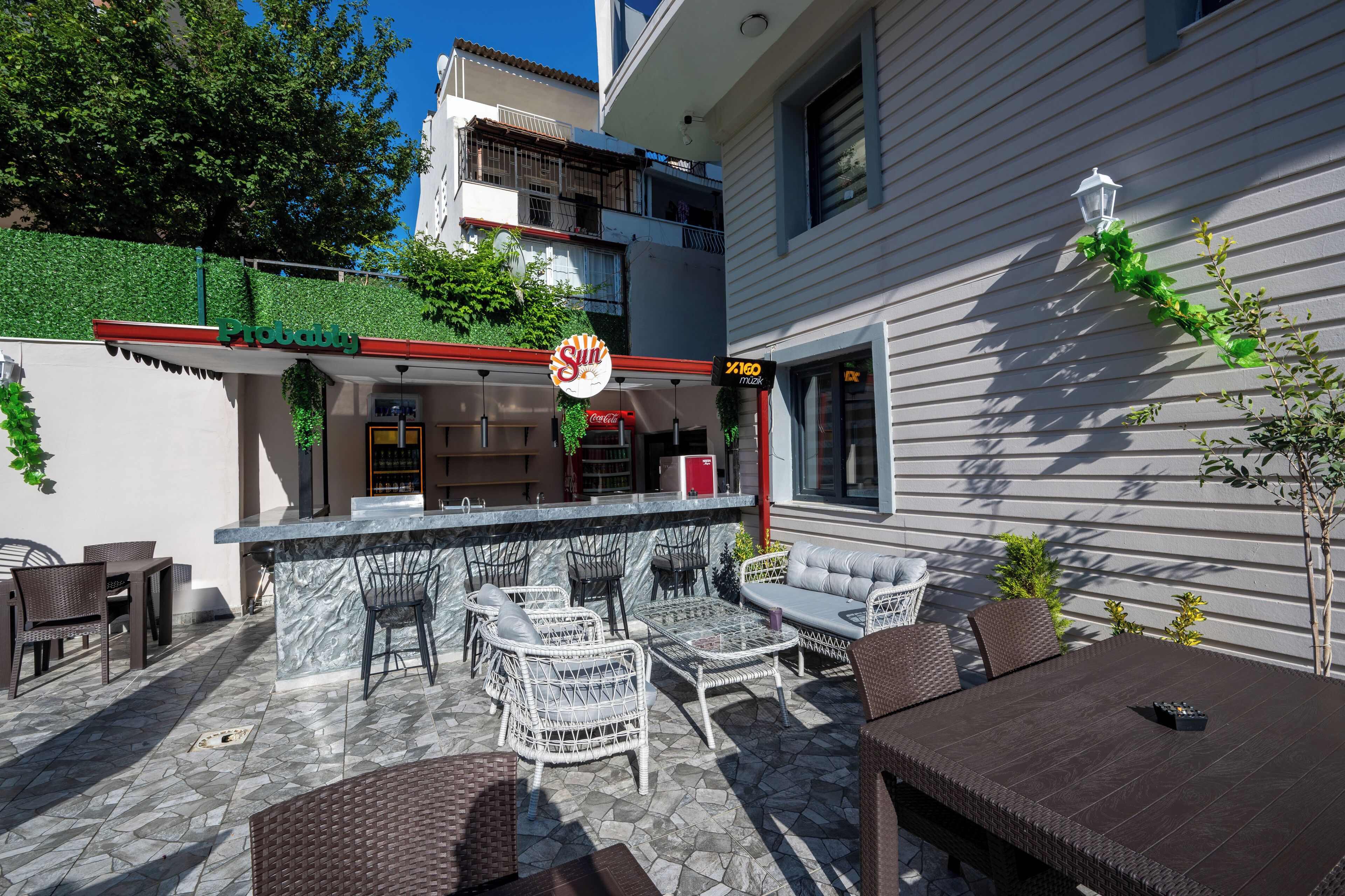 An outdoor patio with wicker furniture, a bar area, and a Coca-Cola sign.