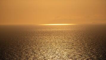 A sunset over a calm sea with a clear horizon.