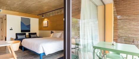 Una habitación de hotel moderna con una cama, una mesita y sillas.