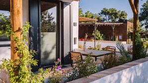 Un bâtiment moderne doté d’un patio couvert, d’un banc en bois et d’une table.