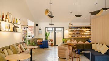 A modern interior with a seating area, a coffee table, a bookshelf, and a door leading outside.