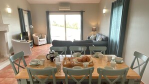 A dining area with a wooden table set for breakfast, surrounded by green chairs. - Spacious villa Le Charme with heated pool, 4 bedrooms sleeping 9, Airco & WiFi (Chalais)