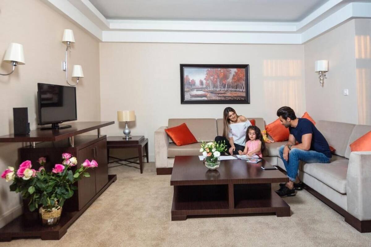 A living room with a sofa, coffee table, TV, and decorative items.