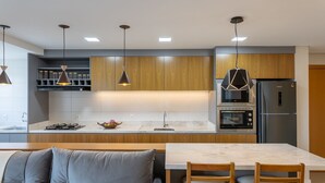Una cocina moderna con armarios de madera, horno empotrado y refrigerador.