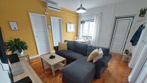A living room with a sofa, a coffee table, and a potted plant.