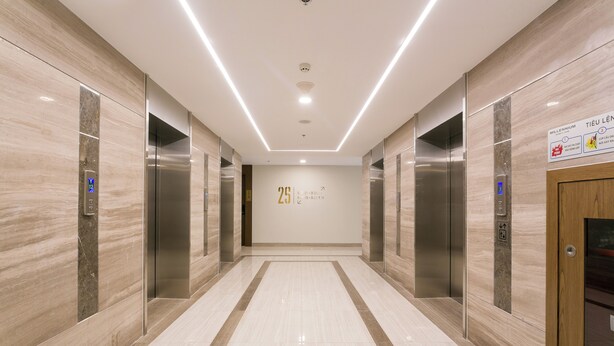 A modern elevator lobby with marble walls, a clean tiled floor, and a sign indicating the 25th floor. - Hapi Riverside Apartment (Ho Chi Minh City)
