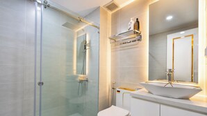 A modern bathroom with a glass-enclosed shower, a white toilet, and a vanity with a large mirror and a vessel sink. - Hapi Riverside Apartment (Ho Chi Minh City)