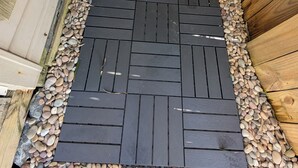 A wooden deck with a black rubber mat and pebbles. - Pelican's Loft: Steps from the beach access  (Carolina Beach)