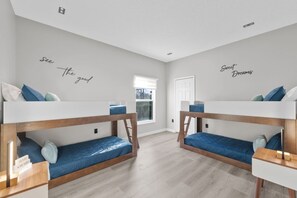 A room with two bunk beds, a window, and motivational wall art. - 5390 Vacation Sunset House Private Pool Grill (Kissimmee)