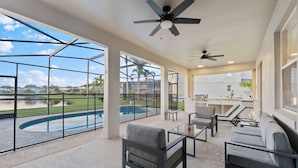 Une vaste terrasse dotée d’une piscine, de mobilier d’extérieur et offrant une vue sur un quartier résidentiel.