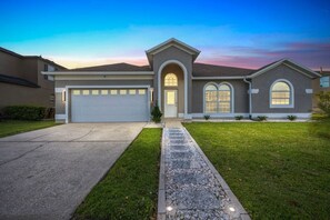 A modern two-story house with a garage, a driveway, and a well-maintained lawn.