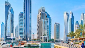 A marina with boats and a city skyline with modern high-rise buildings.