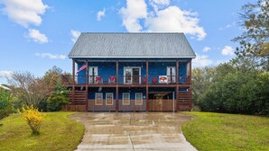 A two-story building with a balcony, a flag, and a sign that reads "The Red Buffalo." - Red Buffalo| Steps to beach and town. (Emerald Isle)