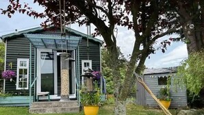 A small house with a porch, a hammock, and potted plants. - Delightful Tiny House with stunning views in the Dublin Mountains!

 (Dublin)