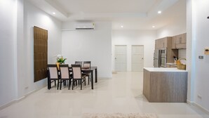 A modern kitchen with built-in appliances and a dining area with a table and chairs. - Cosy and relaxing pool villa, 10 min to the beach and shopping. Family friendly. (Hua Hin)