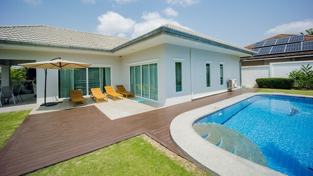 A modern house with a swimming pool, a covered patio with lounge chairs, and solar panels on the roof. - Cosy and relaxing pool villa, 10 min to the beach and shopping. Family friendly. (Hua Hin)