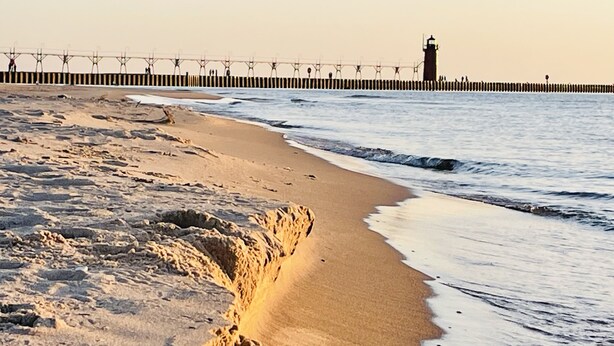 A beach with a rocky outcrop and a lighthouse in the background. - Peaceful Creekside Hideaway Near Town (South Haven)
