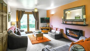 A living room with a fireplace, a television, and a sofa. - Pine Lodge - UK46679 (Bridgnorth and Ironbridge)