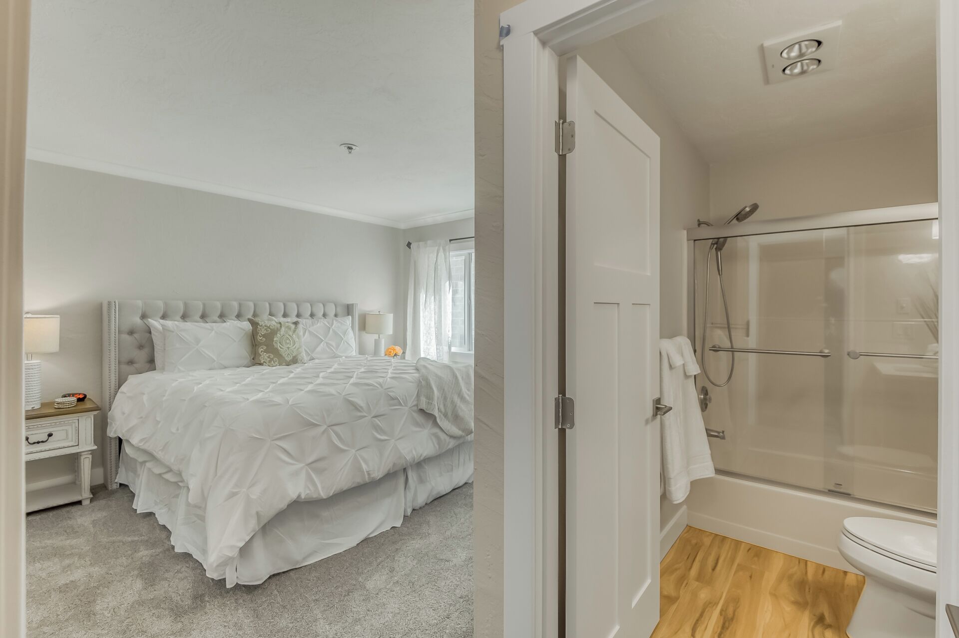 Une chambre à coucher avec un grand lit, une table de chevet et une commode.