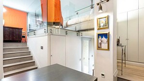 A modern interior with a staircase, a bunk bed, and a dining area.