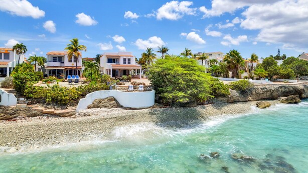 Une propriété située sur la côte, offrant une vue sur la plage, comprenant plusieurs villas et entourée d’une végétation luxuriante.