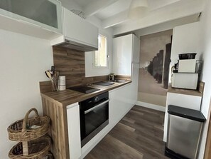 Een moderne keuken met een houten aanrechtblad, een ingebouwde oven en roestvrijstalen apparatuur.