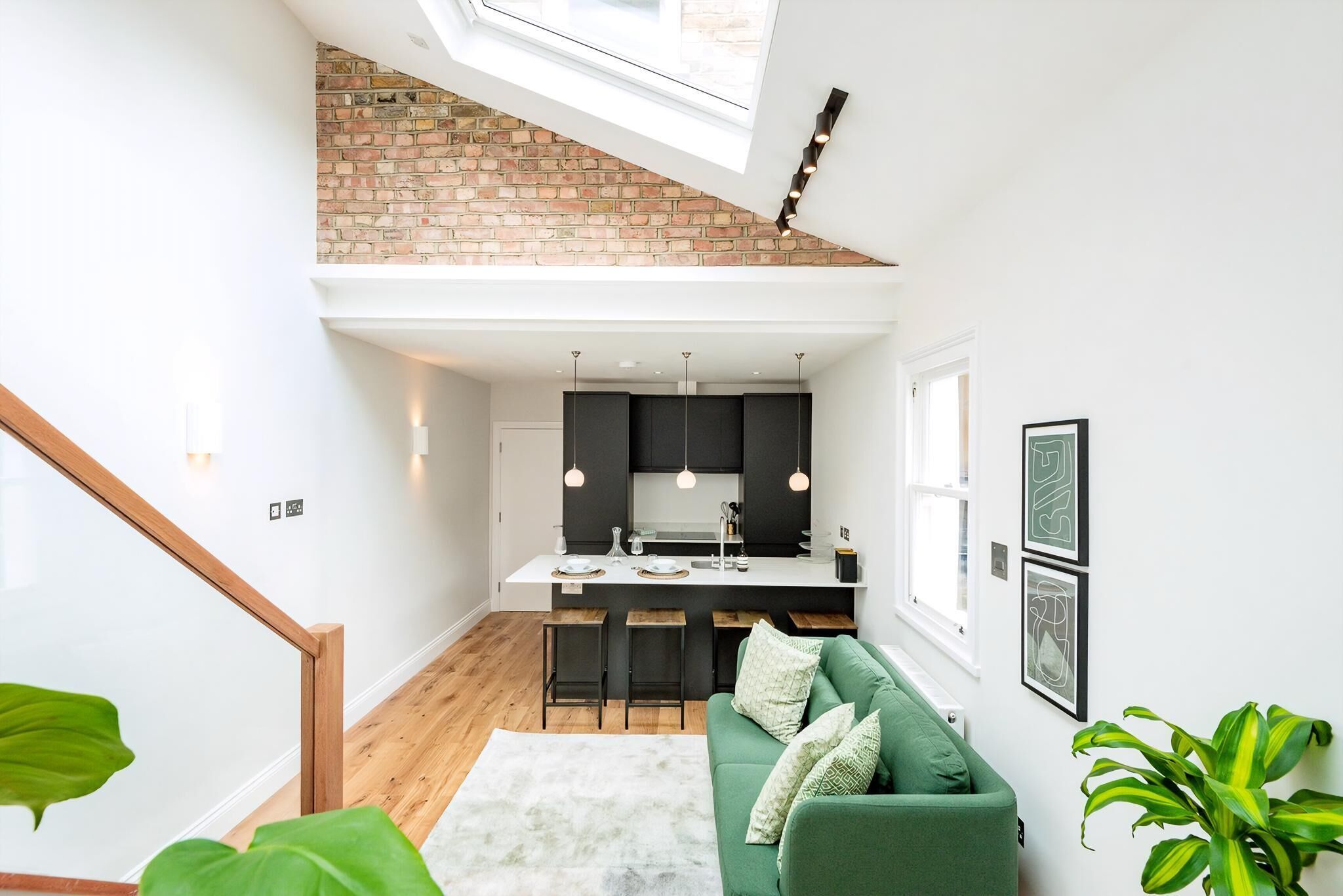 Een moderne keuken met een bakstenen muur, hanglampen en een centraal eiland.
