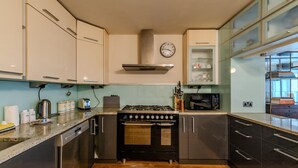 A modern kitchen with stainless steel appliances, a built-in oven, and a microwave. - Beautiful Three Bedroom House in West London (London)