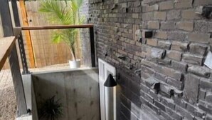 A narrow stairway leading to a door, with a small potted plant on the landing.