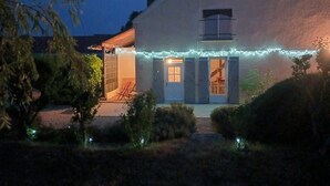 Uma casa com varanda coberta, antena parabólica e luzes de Natal.