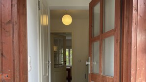 A hallway with wooden doors and a light fixture. - Ruhig und Idyllisch: Kleines Ferienhaus am Waldrand - S-bahn-nähe - Zentrumsnah (Bergisch Gladbach)