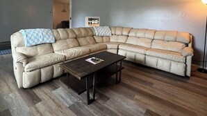 A living room with a sectional sofa, a coffee table, and a floor lamp.