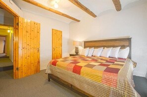 Cozy retreat with a large bed and a nightstand featuring a lamp.