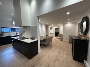 Enjoy a spacious open-plan layout with a kitchen, dining area, and living space, featuring a large island with a gas stove and ample counter space.