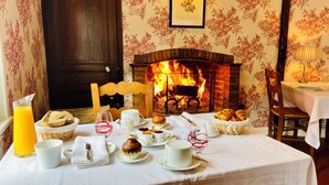 Un desayuno con chimenea, pan, pasteles y un vaso de jugo de naranja.
