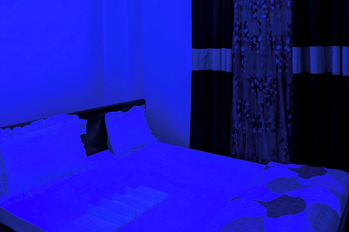 A bedroom with a bed, curtains, and a ceiling light.