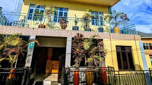 A two-story building with a flat roof, large windows, and a balcony with potted plants. - URBAN VIBER MOTEL (Kigali)