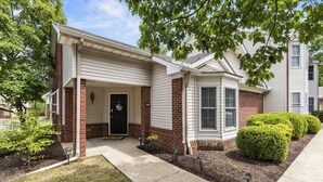 A two-story residential building with a front porch, brick accents, and a well-maintained lawn. - Castle Glow - 2BR - BBQ Gr - Walk to Kroger Field (Lexington)
