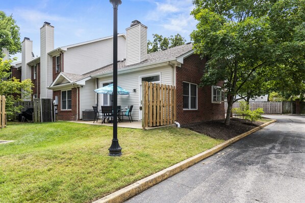A two-story house with a front porch, a wooden fence, and a small tree. - Castle Glow - 2BR - BBQ Gr - Walk to Kroger Field (Lexington)